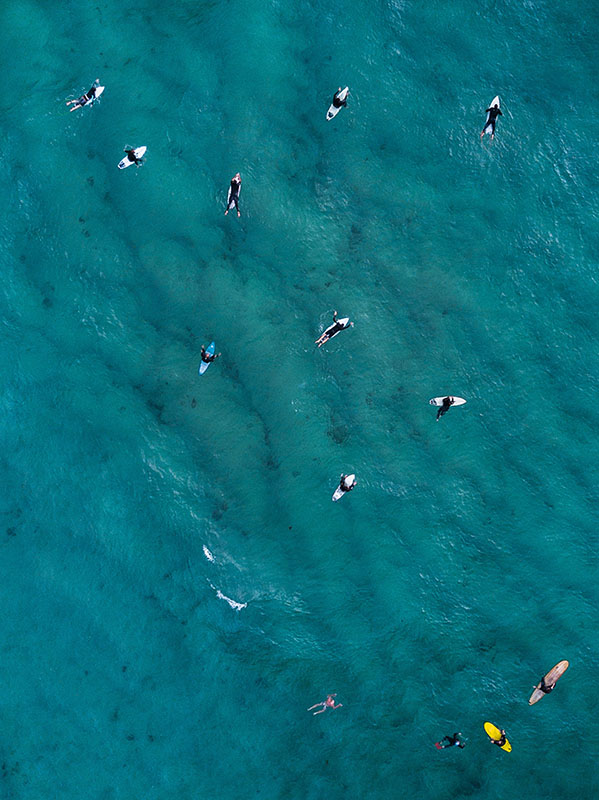 Mar visto desde el aire con varios surfistas.